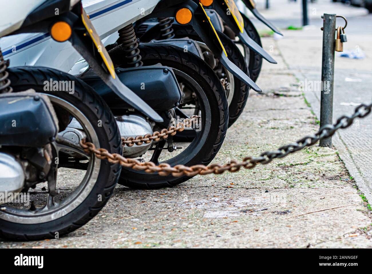 Le ruote posteriori della pizza consegna catena scooter sono bloccati con una catena antifurto - immagine Foto Stock