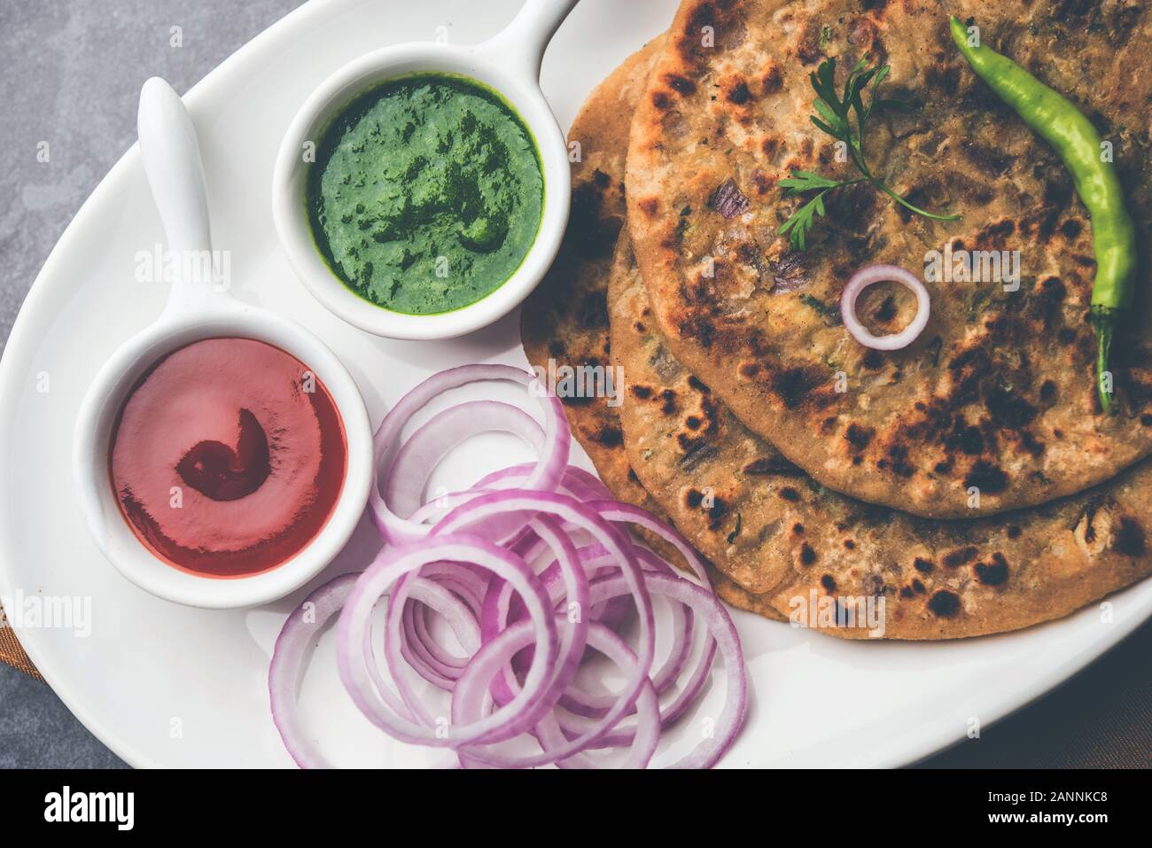 Parotha di cipolla / Pyaj parantha / kanda paratha servito con ketchup di pomodoro e chutney verde. Fuoco selettivo Foto Stock