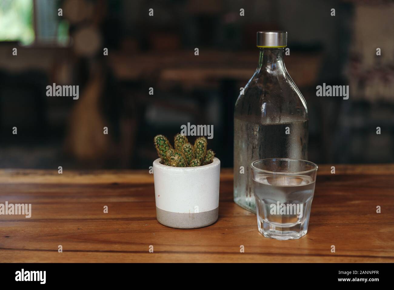 Acqua potabile. Bicchiere di acqua con una bottiglia sul tavolo Foto Stock