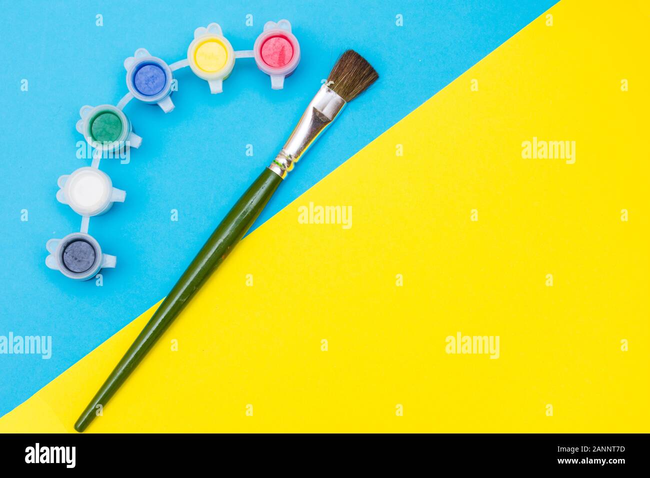 Giallo e blu vibranti colori luminosi arte flatlay concetto con paintbrushe verde acqua e vernici colorate che illustra la creatività, ispirazione e Foto Stock