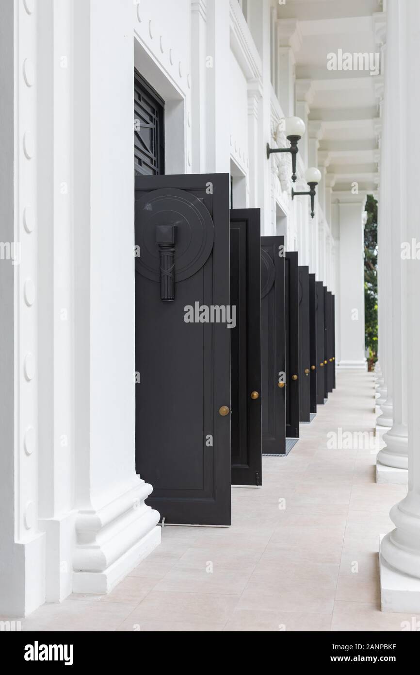 Ingresso con porte nere aperte all'edificio del College of Medicine a Singapore Foto Stock