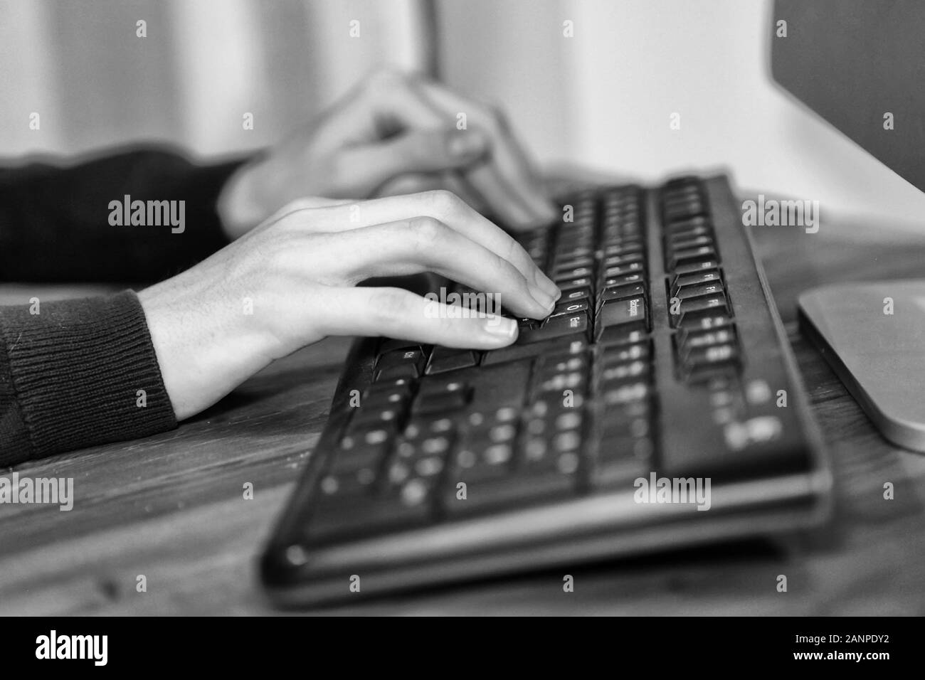 Immagine in bianco e nero di un business le mani lavorando e digitando sulla tastiera del notebook in ufficio Foto Stock