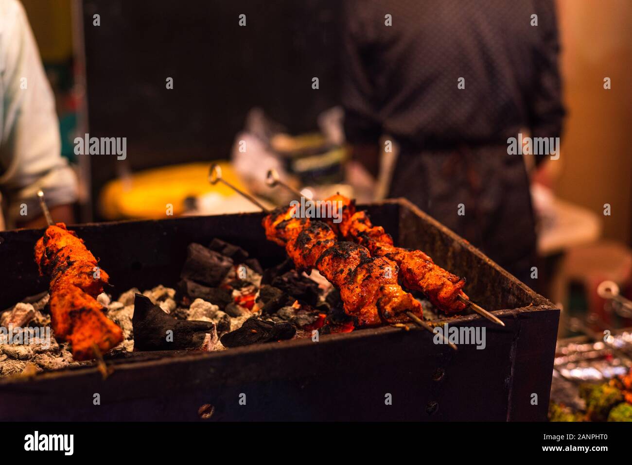 Street food/tradizionale tandoori alla griglia di carni assortite con carbone e fuoco su spiedini Foto Stock