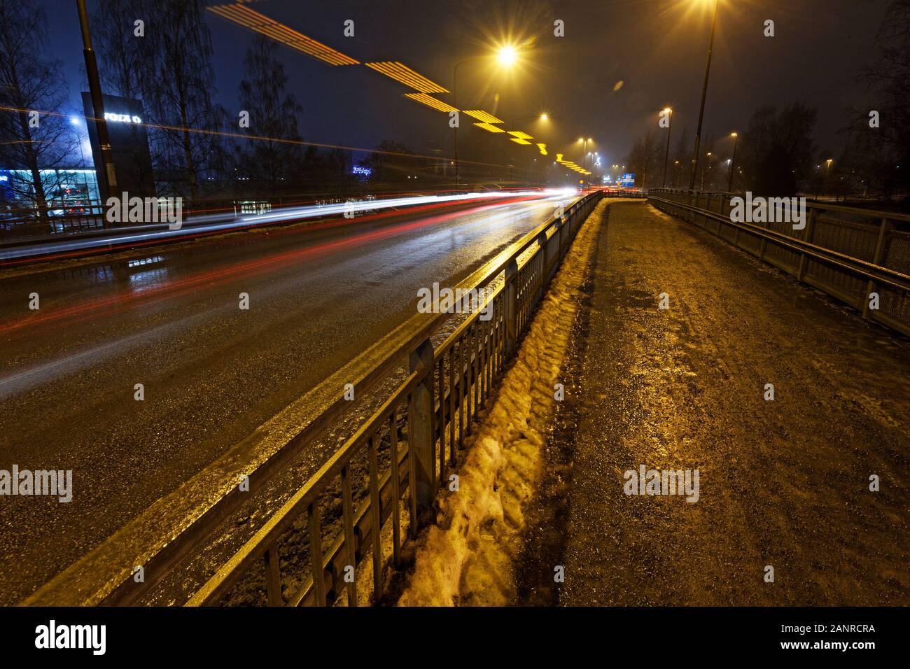 Umea, Norrland Svezia - 26 Novembre 2019: Ponte di notte con la neve e la luce tracciato da auto Foto Stock