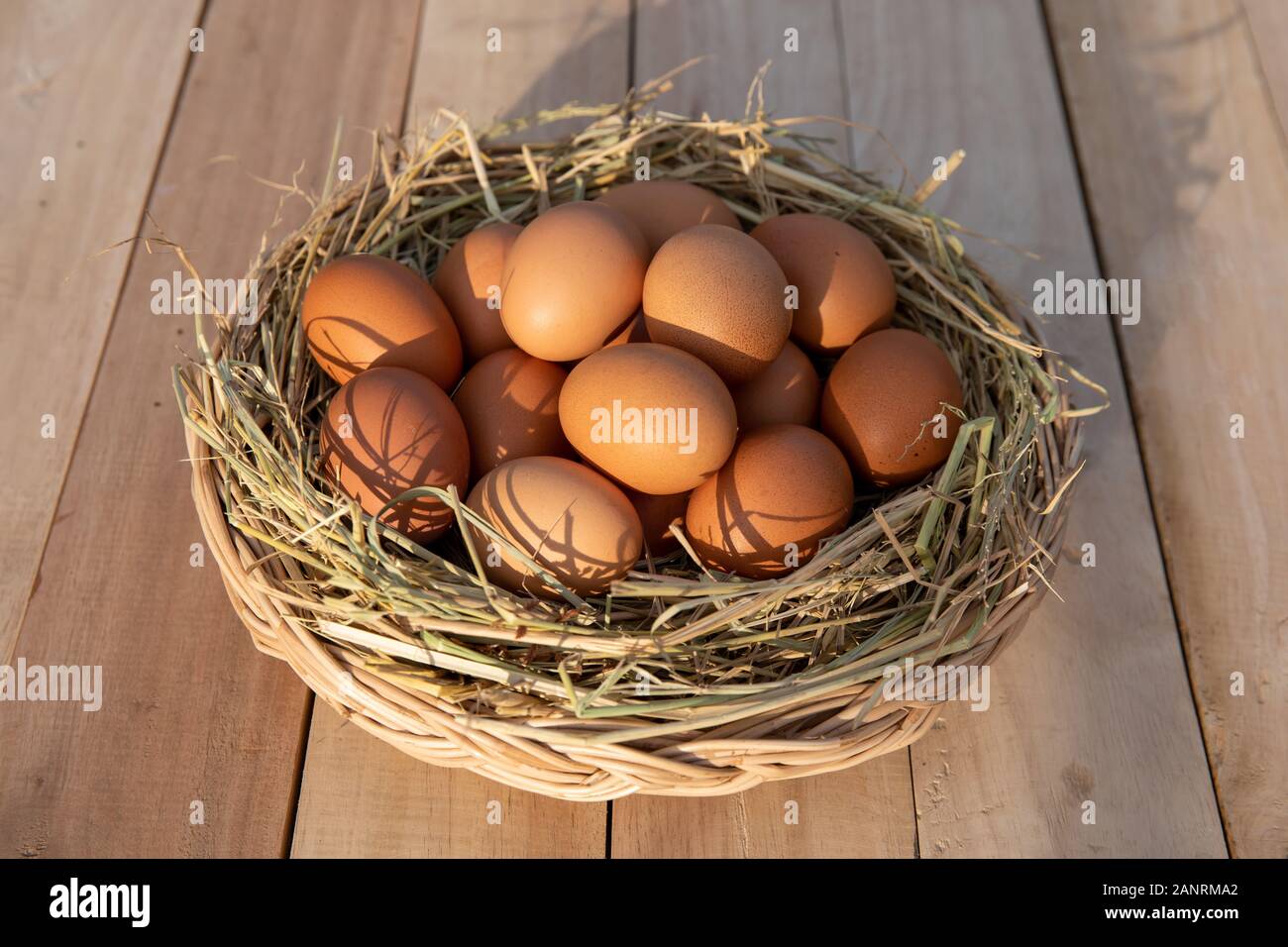 Cesto di uova sul pavimento in legno Foto Stock