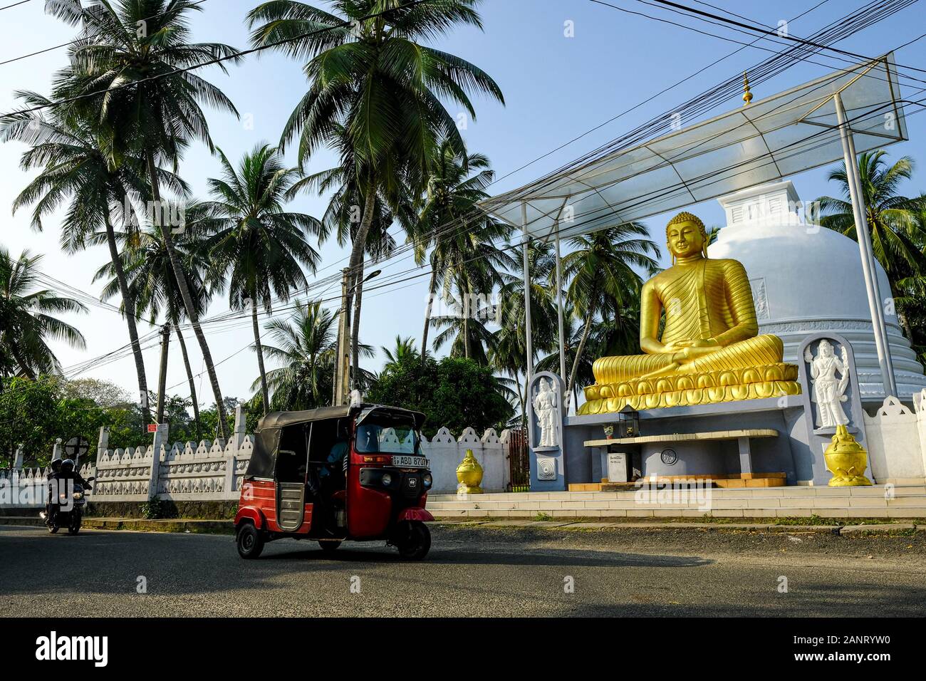 Galle, Sri Lanka - Gennaio 2020: Un tuk tuk che passa davanti alla statua del Buddha in una strada a Galle il 15 gennaio 2020 a Galle, Sri Lanka. Foto Stock