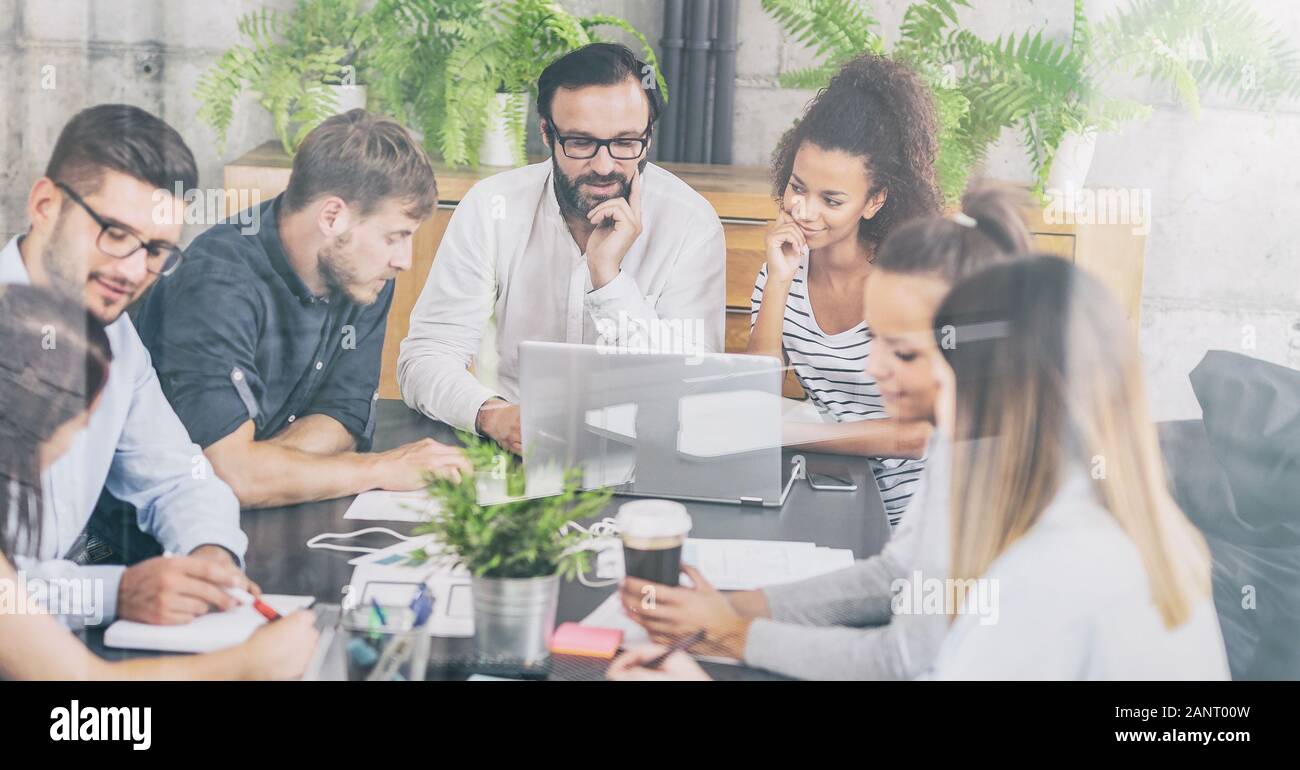 I giovani uomini di affari riunione in ufficio e discutendo insieme un nuovo progetto di avvio. Foto Stock