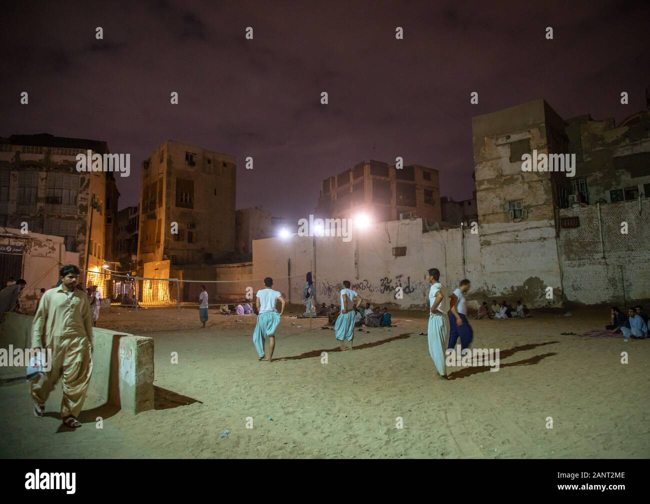 Gli uomini la riproduzione di beach volley di fronte vecchie case con mashrabiyas di al-Balad trimestre, Mecca provincia, Jeddah, Arabia Saudita Foto Stock