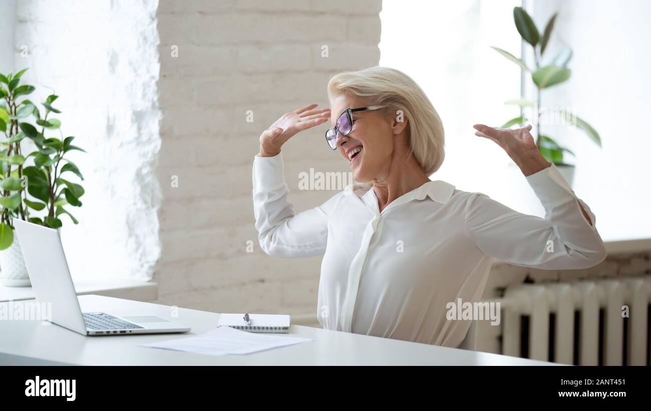 Età imprenditrice rilassante sulla sedia bracci di estensione godetevi i giorni lavorativi termina Foto Stock