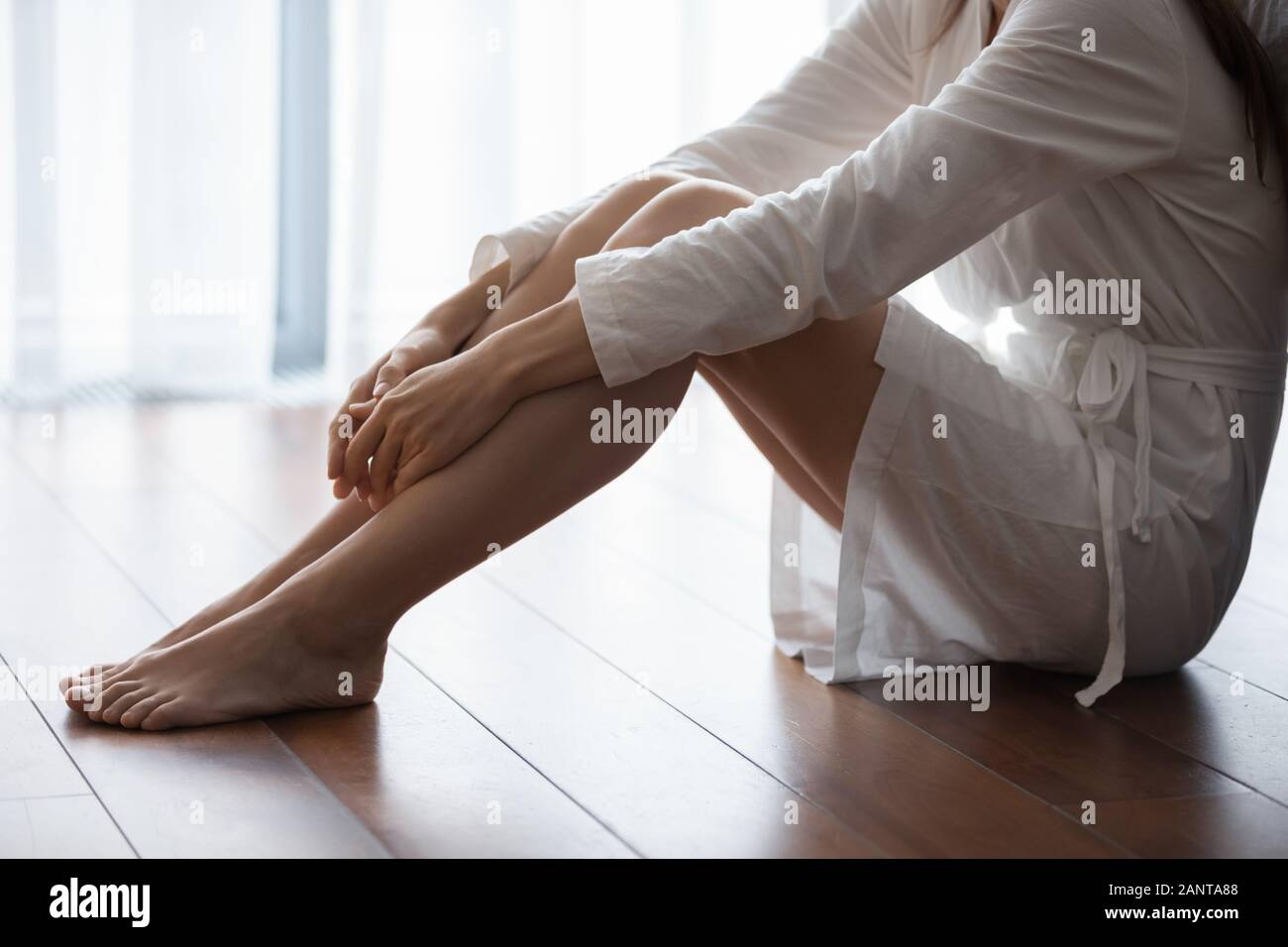 Close up infelice donna seduta sul pavimento da soli, sentirsi depressi Foto Stock