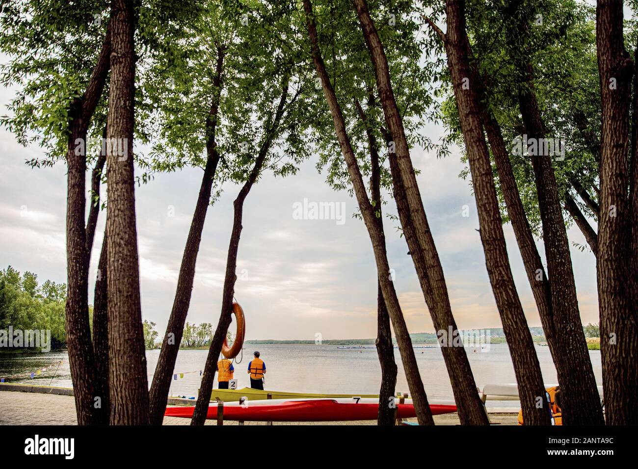 Scuola di sport kayak e canoa. vista dalla riva alla concorrenza al tramonto Foto Stock