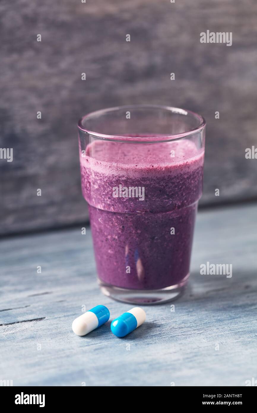 Bicchiere di Protein Shake con latte e mirtilli e creatina capsule.  Concetto di Sport Nutrition Foto stock - Alamy