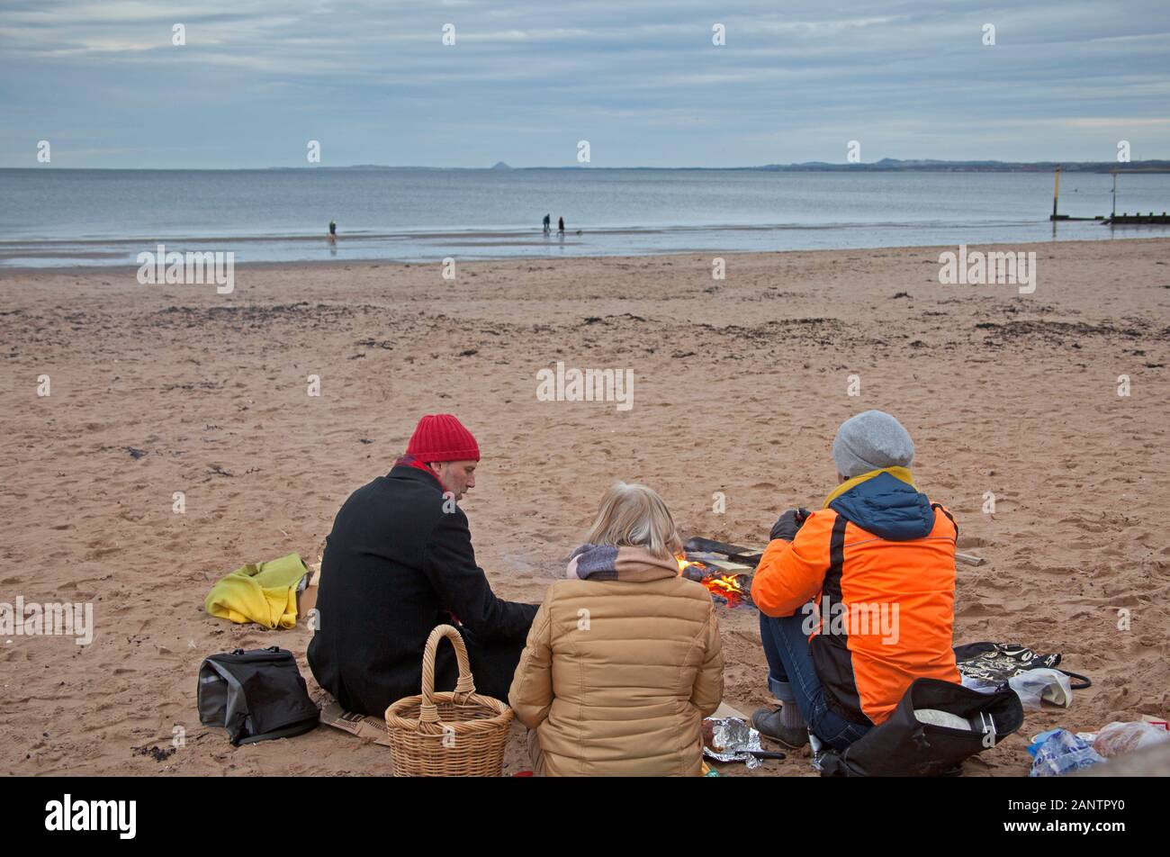 Portobello Beach, Edimburgo, Scozia, Regno Unito. 19th gennaio 2020. Mentre gli studenti dell'Università di Edimburgo pensavano che 6 gradi centigradi non fossero male per fare un bagno veloce, altri decisero di fare un pic-nic intorno a un fuoco sulla spiaggia. Foto Stock