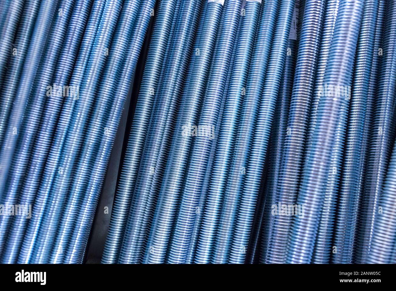 Filettato aste in metallo. Sfondo tecnologico o texture. Una serie di tondini di acciaio filettati possono essere utilizzate come sfondo. Foto Stock