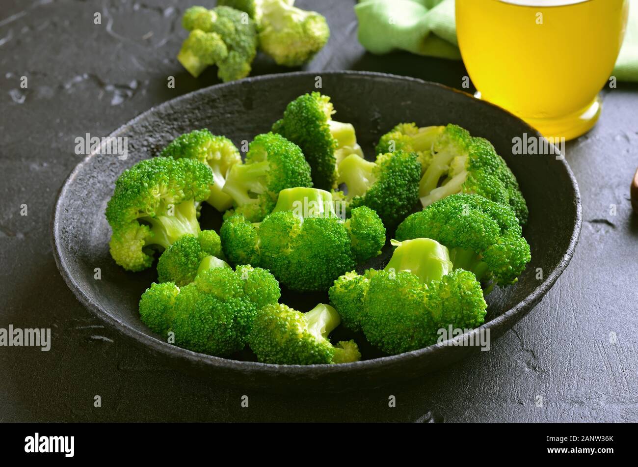 Cibo vegetariano. Broccoletti in padella nera su sfondo di pietra Foto Stock
