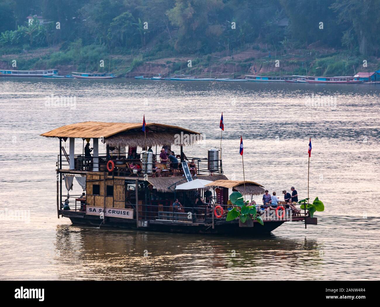 I turisti sul fiume crociera al tramonto, barca del fiume Mekong, Luang Prabang, Laos, sud-est asiatico Foto Stock