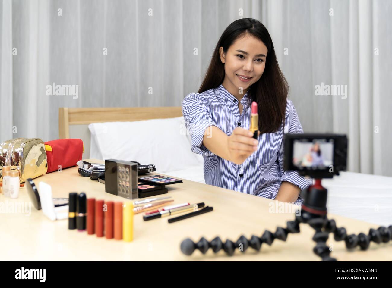 Giovane bella donna asiatica bellezza vlogger o blogger la registrazione live come compongono tutorial per condividere sui social media utilizzando una fotocamera digitale sulla tabella tr Foto Stock