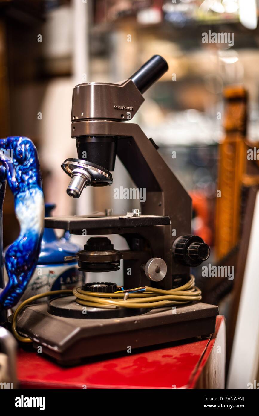 Microscopio invecchiato in piedi su una vecchia casa di legno vecchio articoli vintage vendita garage contenitore di stoccaggio uk manchester london spazio per la pubblicità di testo Foto Stock