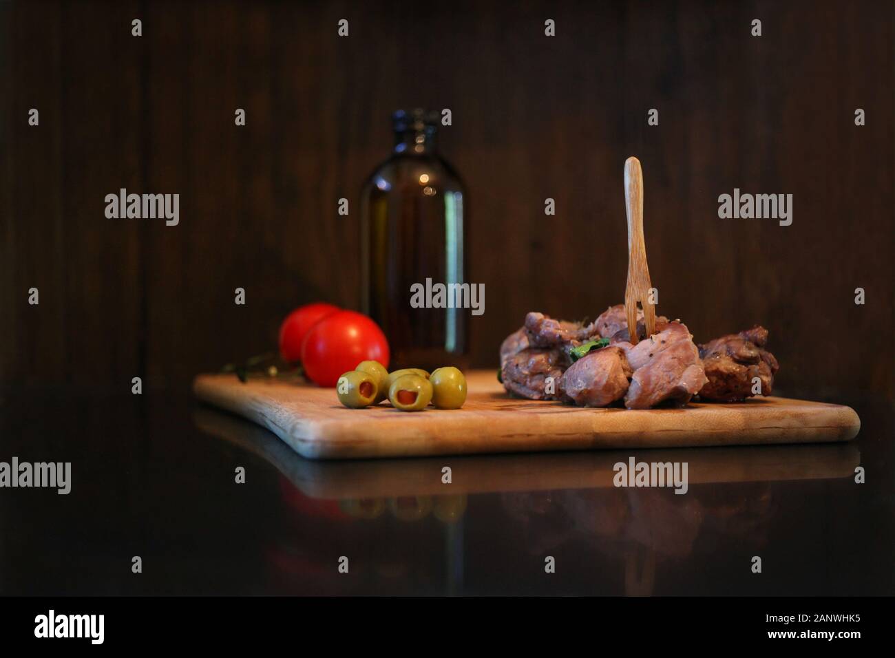 Carne di anatra con pomodori e olive su una tavola di legno. Materie rustico che serve cibo al ristorante. Gourmet di piatti gustosi e concetto di cucina a vista Foto Stock