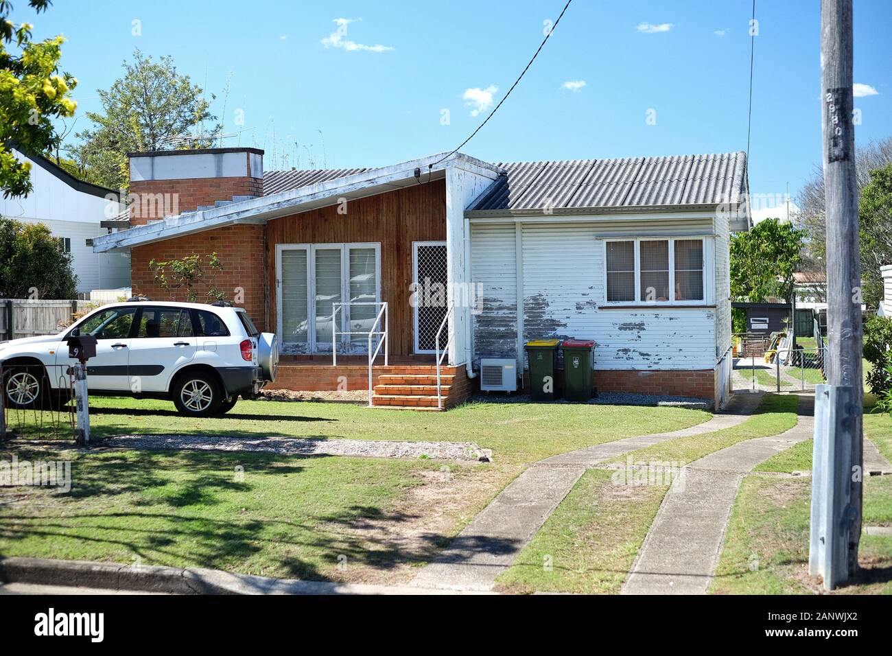 Post War House nei sobborghi di Brisbane di Carina, con tetto di fibro, la loro topografia e moderni 'nuovi queenslander' equivalenti Foto Stock