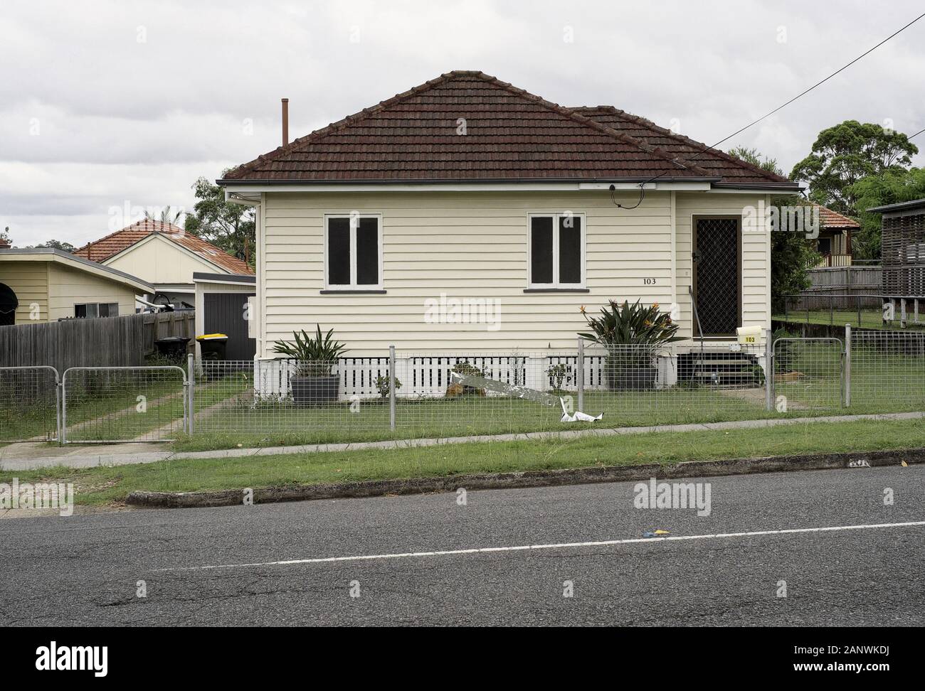 Casa suburbana del dopoguerra, a Box on a Block a Brisbane, Cannon Hill. Sentiero erboso, prato sul prato, nessun albero da far cadere foglie nel grondaia. Foto Stock