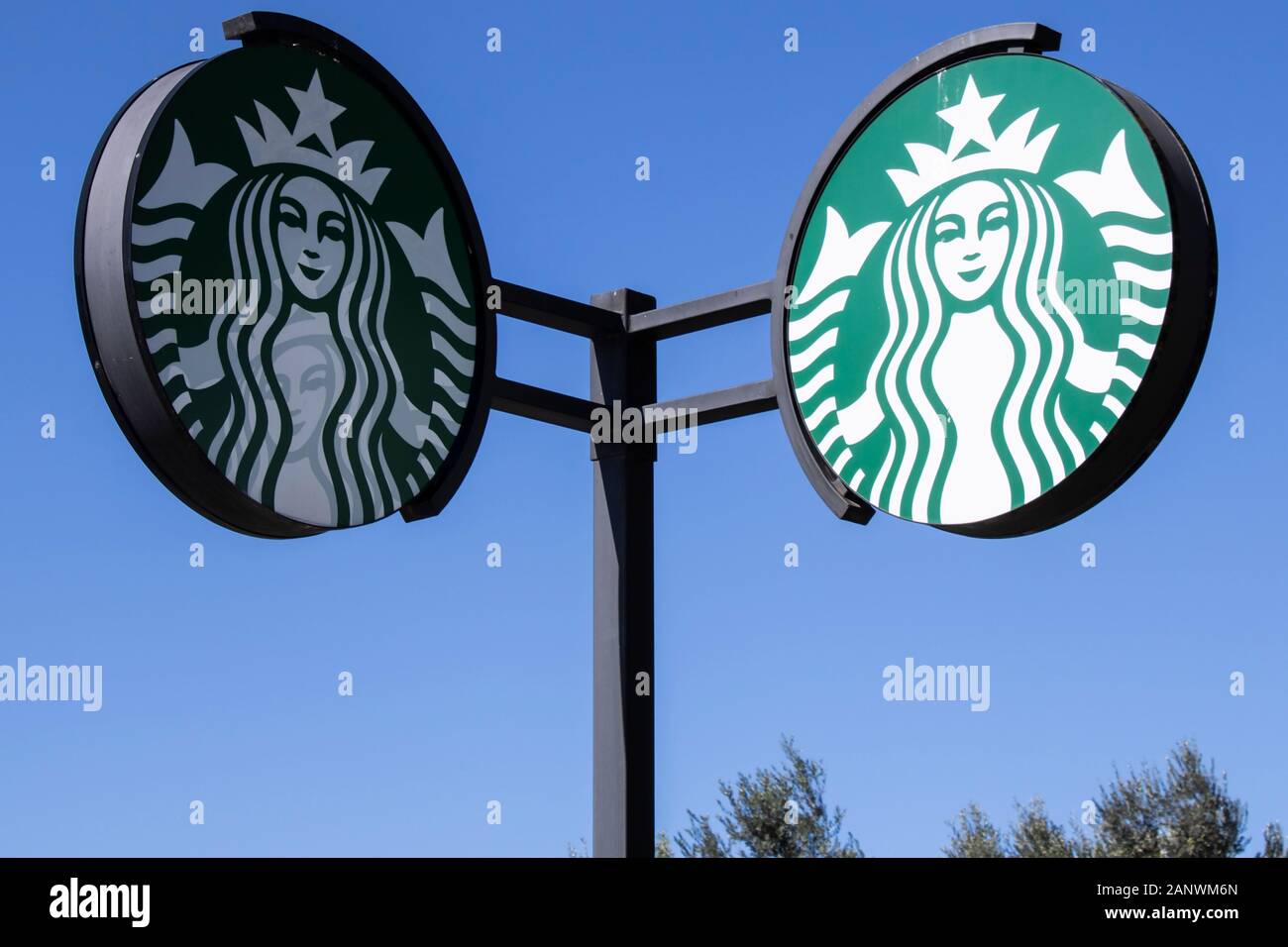 Segno di Starbucks presso la caffetteria Starbucks. Starbucks è un Americano global coffee company e coffeehouse catena venduti in tutto il mondo. Il cielo sereno Foto Stock