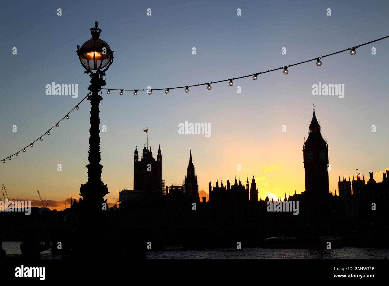 Lampione e vista sul fiume Tamigi da South Bank di Big Ben e Palazzo di Westminster / Case del Parlamento al tramonto, Londra, Inghilterra Foto Stock