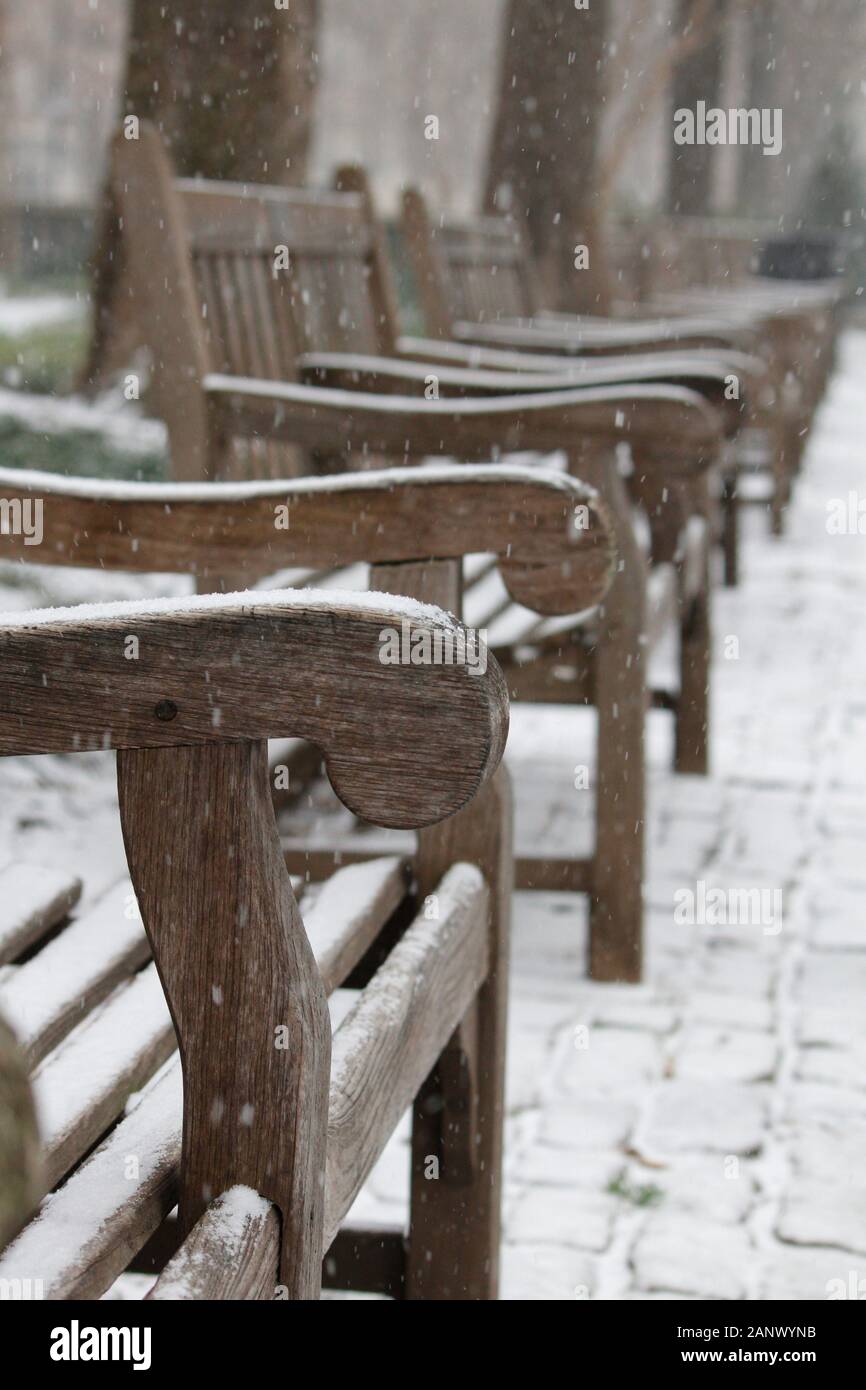 Philadelphia, PA, Stati Uniti d'America - 18 Gennaio 2020: la neve comincia a ricoprire panchine in Piazza Rittenhouse durante la Città della prima tempesta di neve dell'anno. Foto Stock