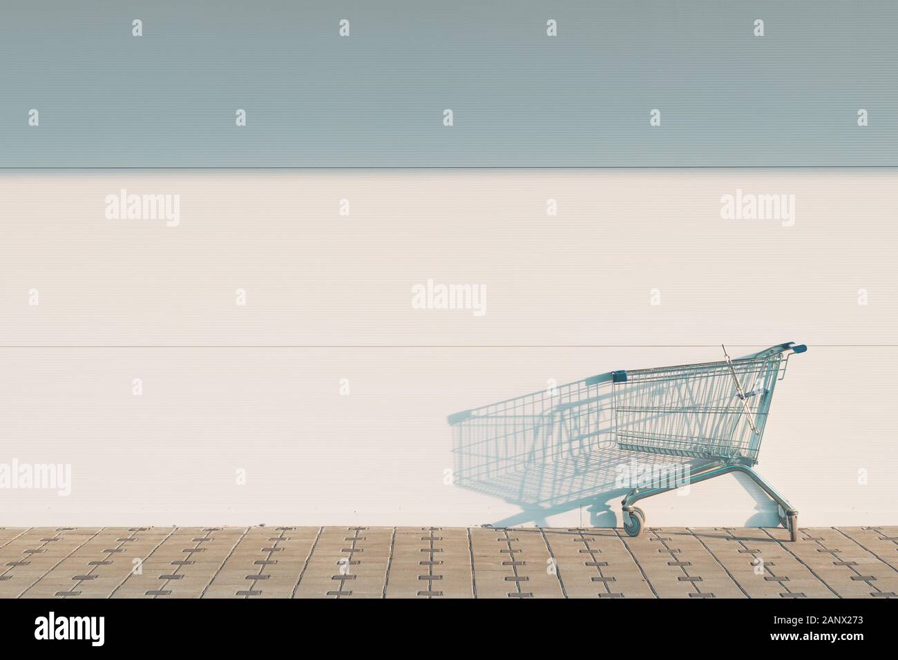 Svuotare il carrello all'esterno del centro commerciale con muro vuoto come spazio di copia Foto Stock