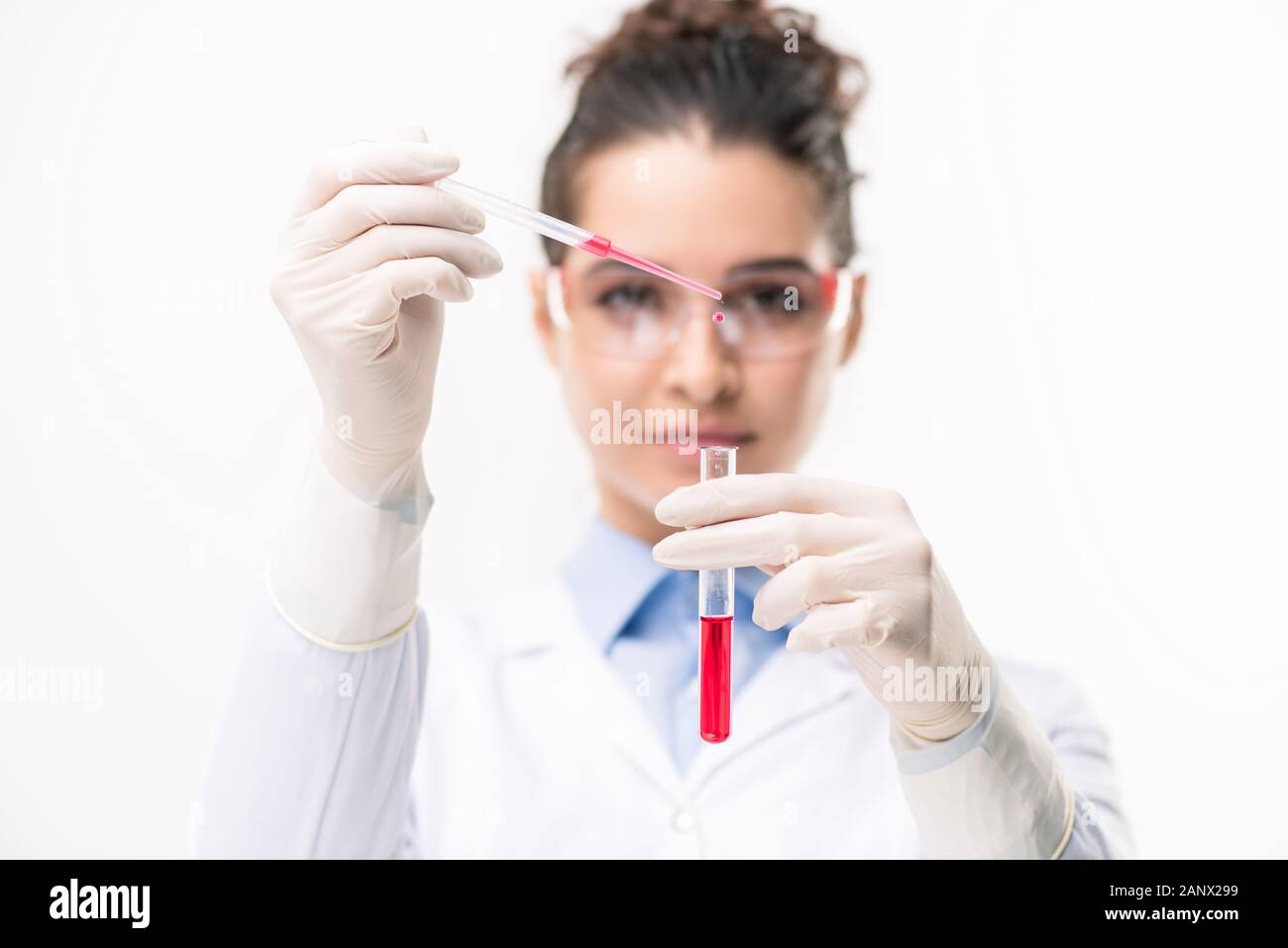 Le mani del medico rosso caduta di sostanza liquida in pallone con un nuovo vaccino Foto Stock