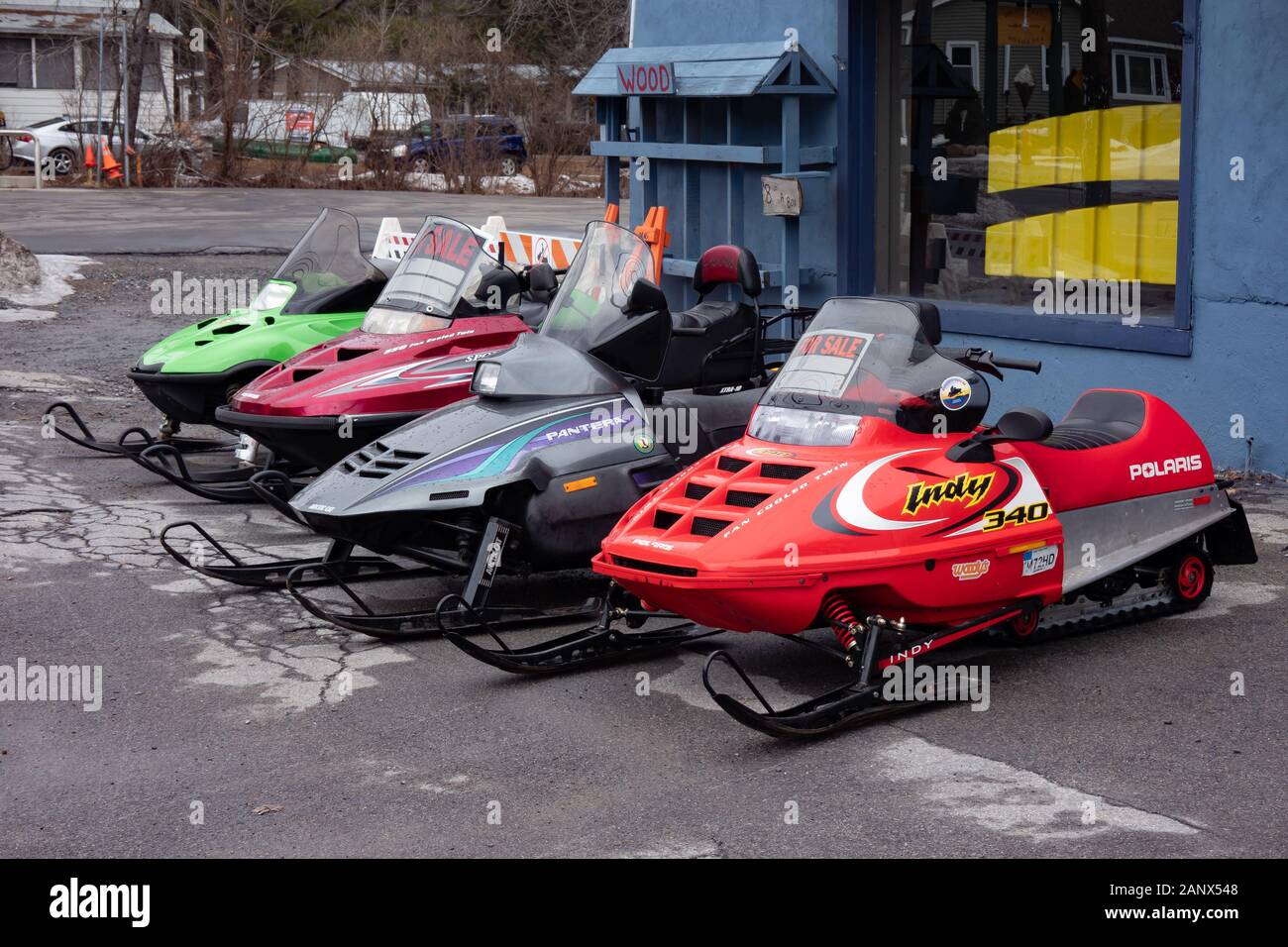 Una linea di quattro usato motoslitte in vendita nella parte anteriore di un business in speculatore, NY USA all'inizio dell'inverno. Foto Stock