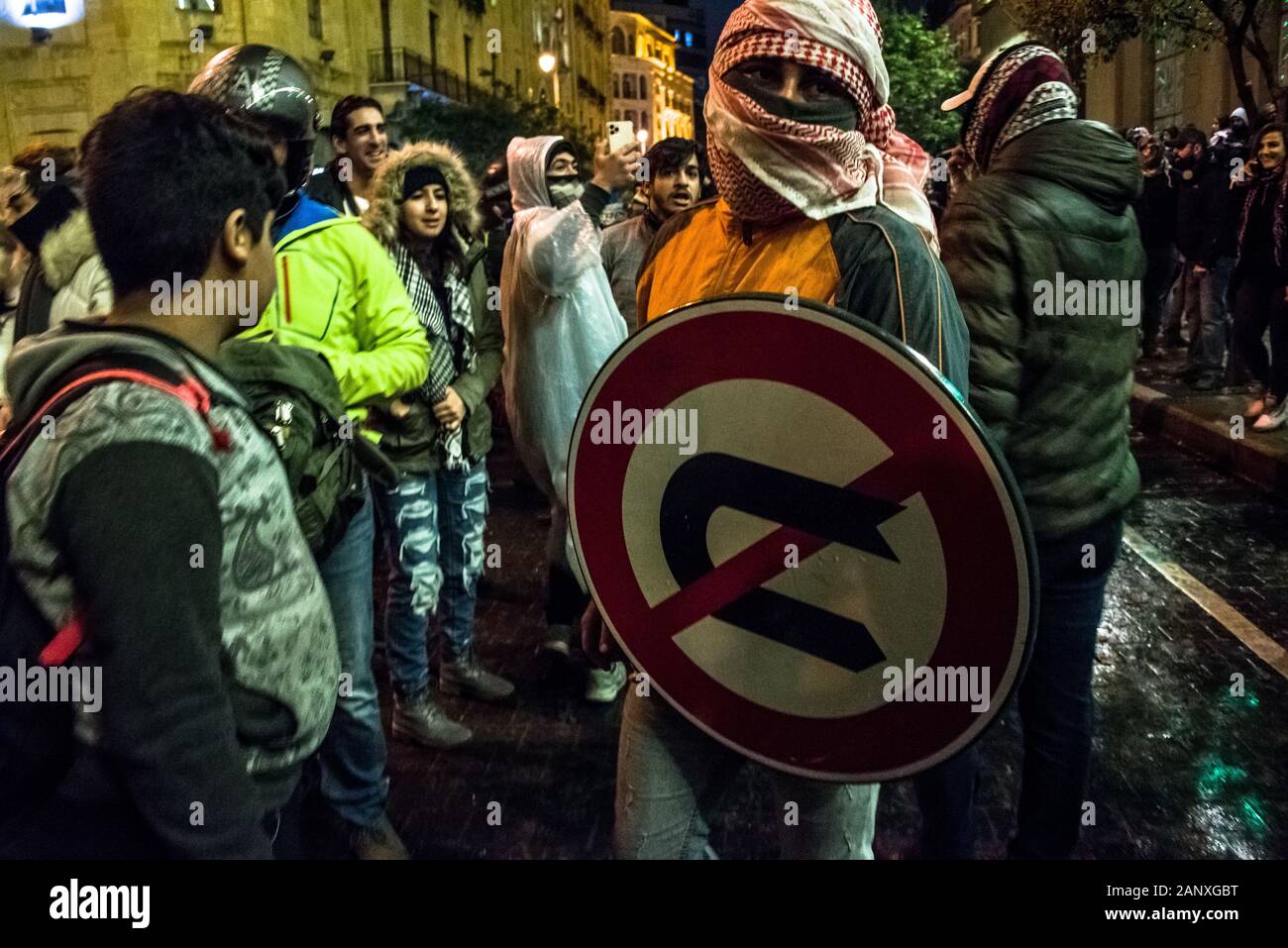 Nessuna inversione ad U. Manifestanti utilizza un cartello stradale come uno scudo come disordini break out tra governo anti-manifestanti e interno delle forze di sicurezza per una seconda notte a Beirut e i libanesi continuano a richiedere i servizi pubblici di base e porre fine alla corruzione politica nel loro paese. Foto Stock