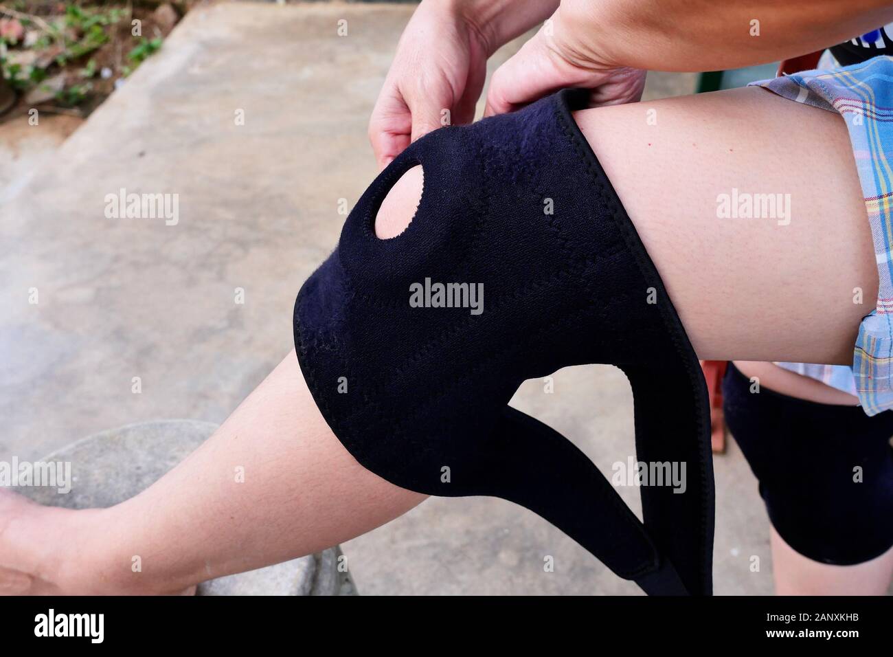 In prossimità del ginocchio la bretella di supporto sulla gamba di una donna di viaggiatori, indossare un equipaggiamento protettivo per mantenere le parti importanti del corpo prima di esercizio Foto Stock