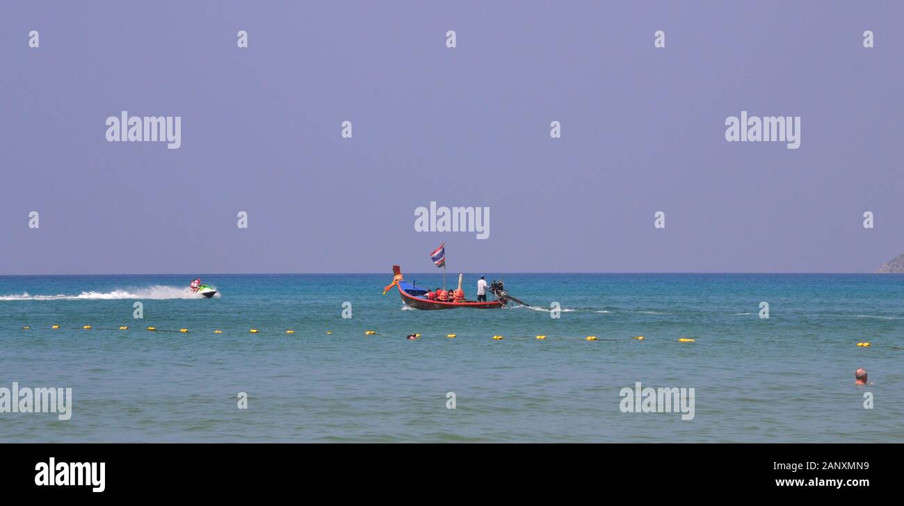 Una barca in riva al mare presso la spiaggia di Patong, Phuket, Thailandia, in Asia, in una giornata calda con un cielo blu Foto Stock