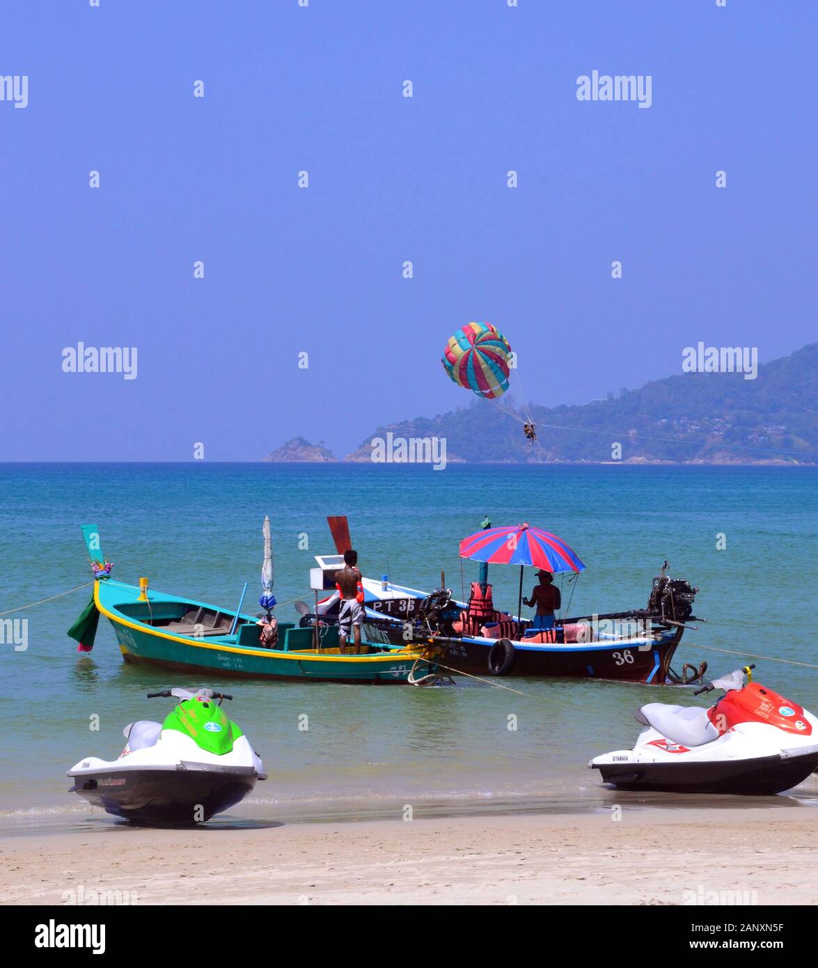 Barche in riva al mare presso la spiaggia di Patong, Phuket, Thailandia, in Asia, in una giornata calda con un cielo blu Foto Stock