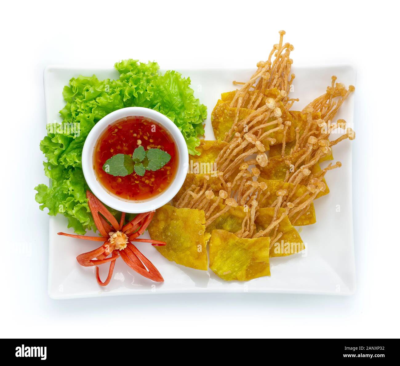 I fagottini croccanti avvolto con aghi dorati funghi servita di salsa al peperoncino dolce cibo tailandese asiatici piatto antipasto decorare con peperoncino intagliato verdure top Foto Stock