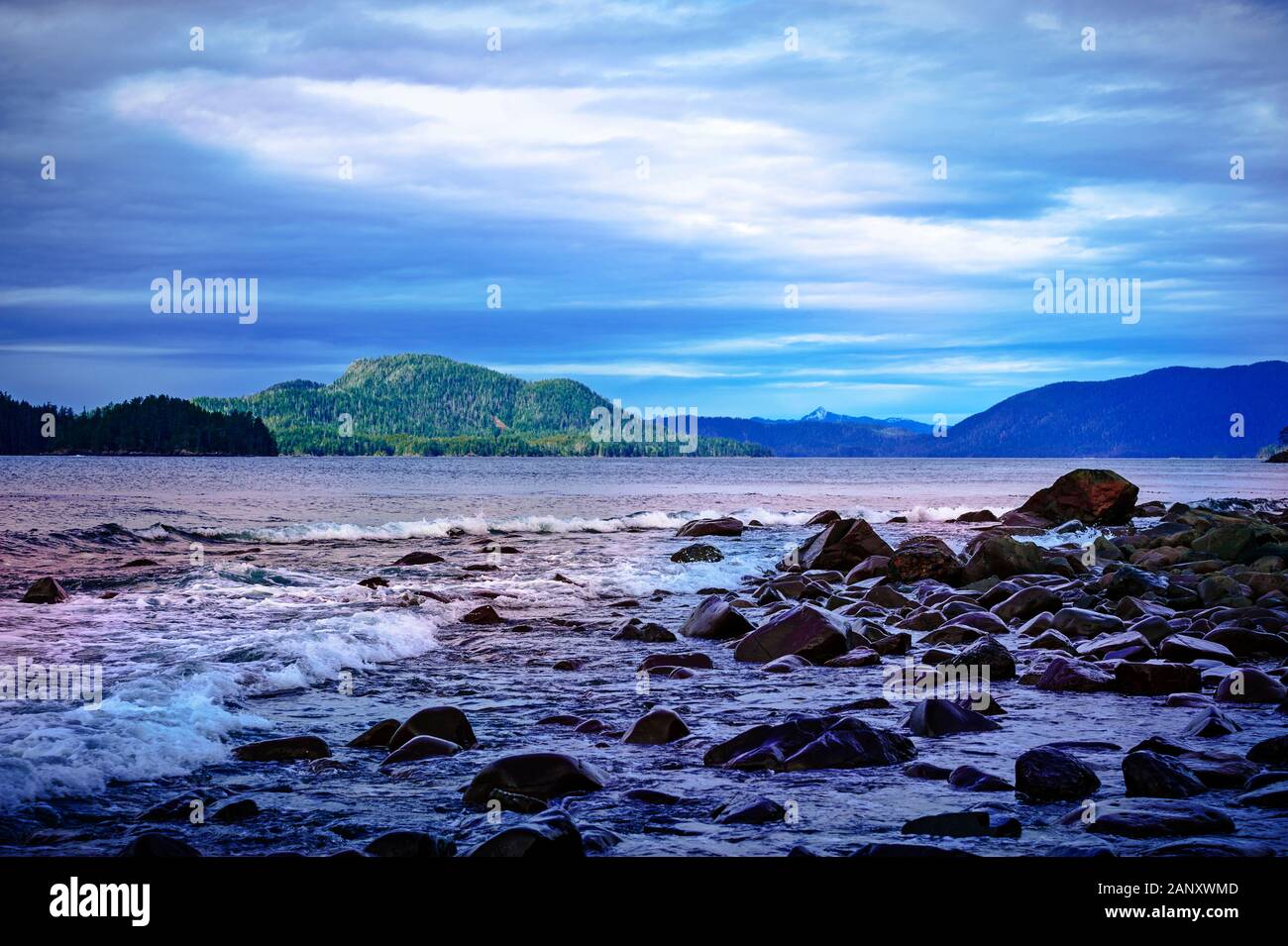 Onde che si infrangono sulla spiaggia rocciosa lungo Sitka Sound vicino a Sitka, Alaska, Stati Uniti d'America. Foto Stock