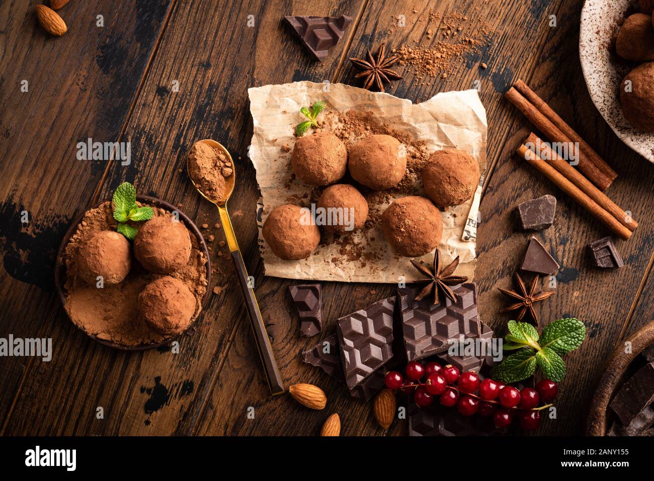 In casa vegan tartufi di cioccolato con materie di cacao in polvere su di un tavolo di legno sfondo, vista dall'alto Foto Stock