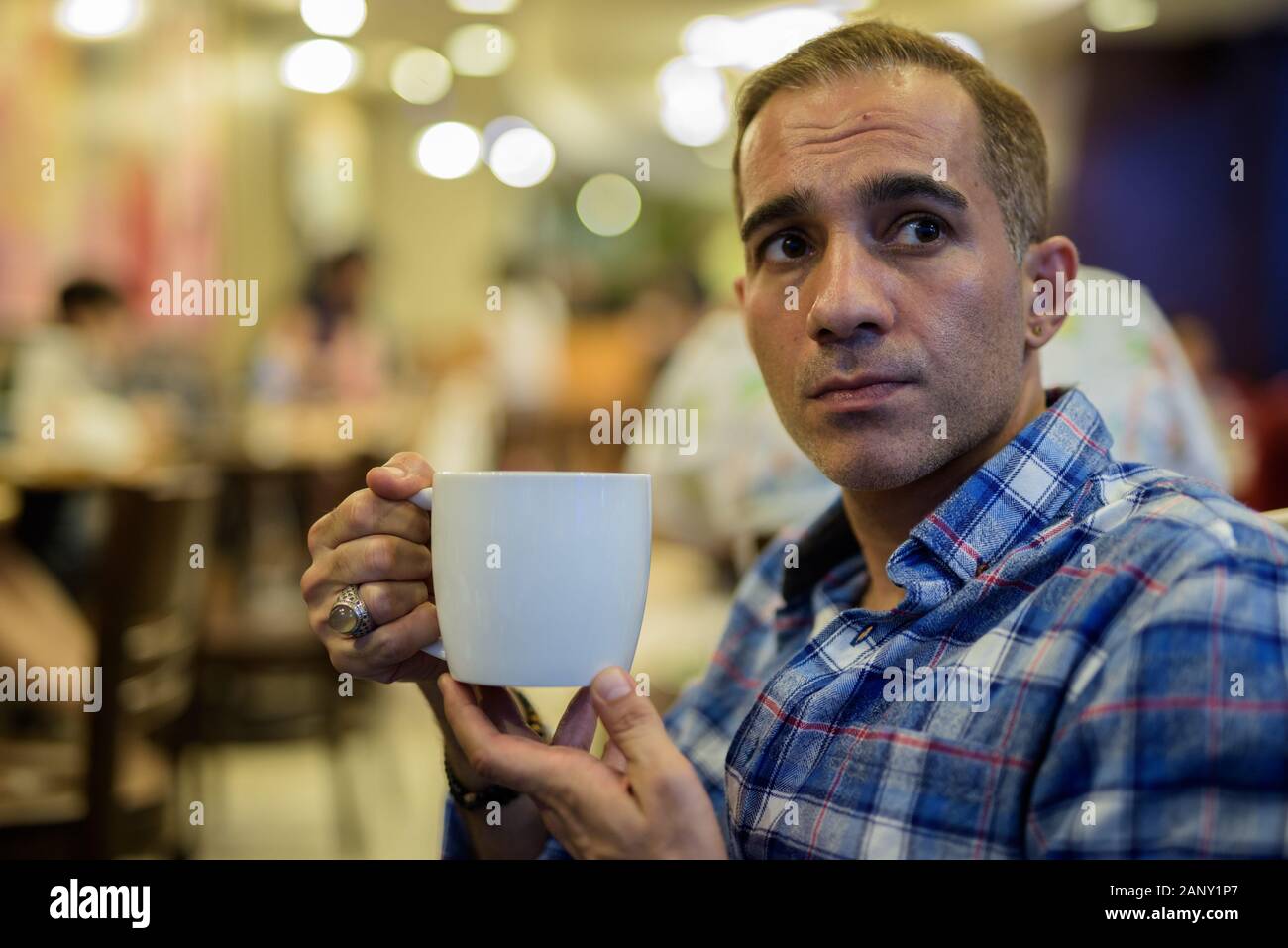 Maturo uomo persiano rilassante all'interno del coffee shop Foto Stock