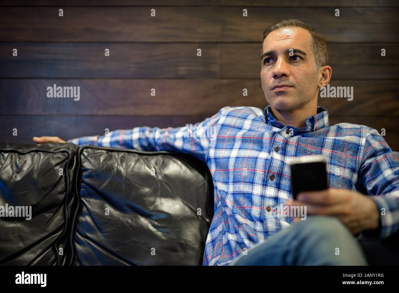 Maturo uomo persiano rilassante all'interno del coffee shop Foto Stock