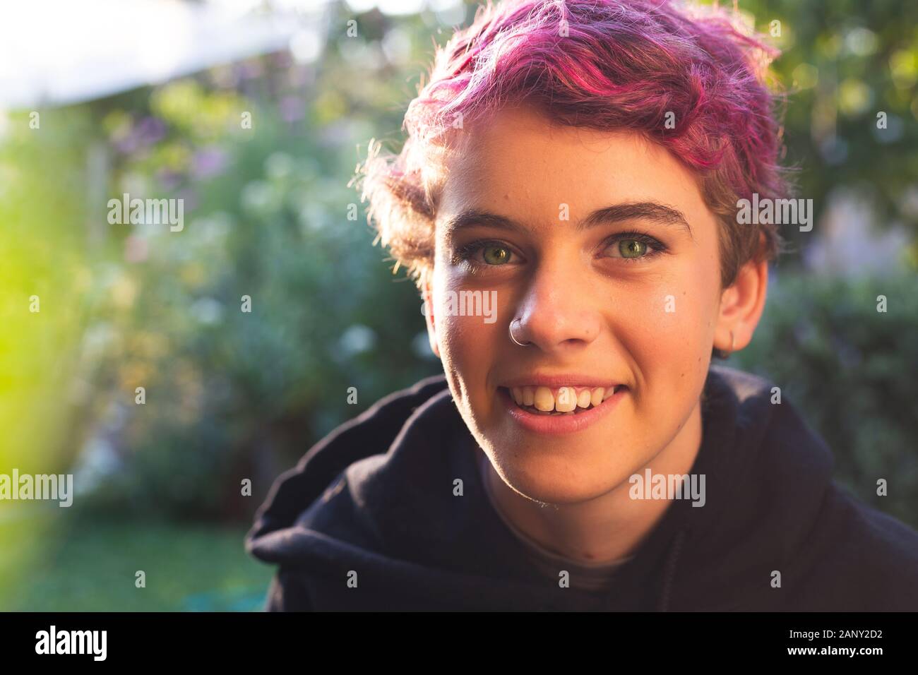 Ritratto di felice, sorridente ragazza con i capelli corti in vivaci e naturali, impostazione esterna Foto Stock