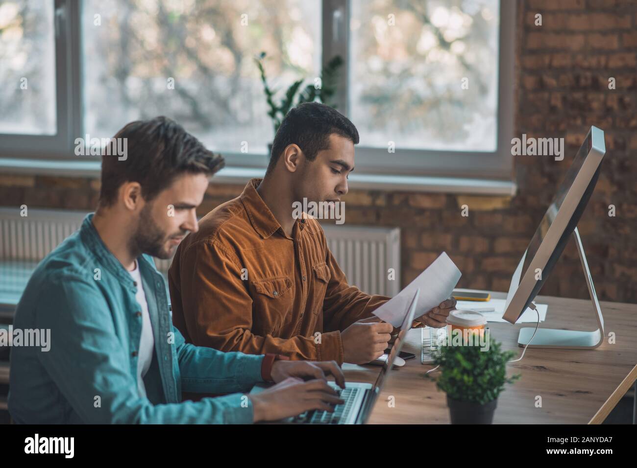 Grave di giovani uomini concentrandosi sul loro lavoro Foto Stock