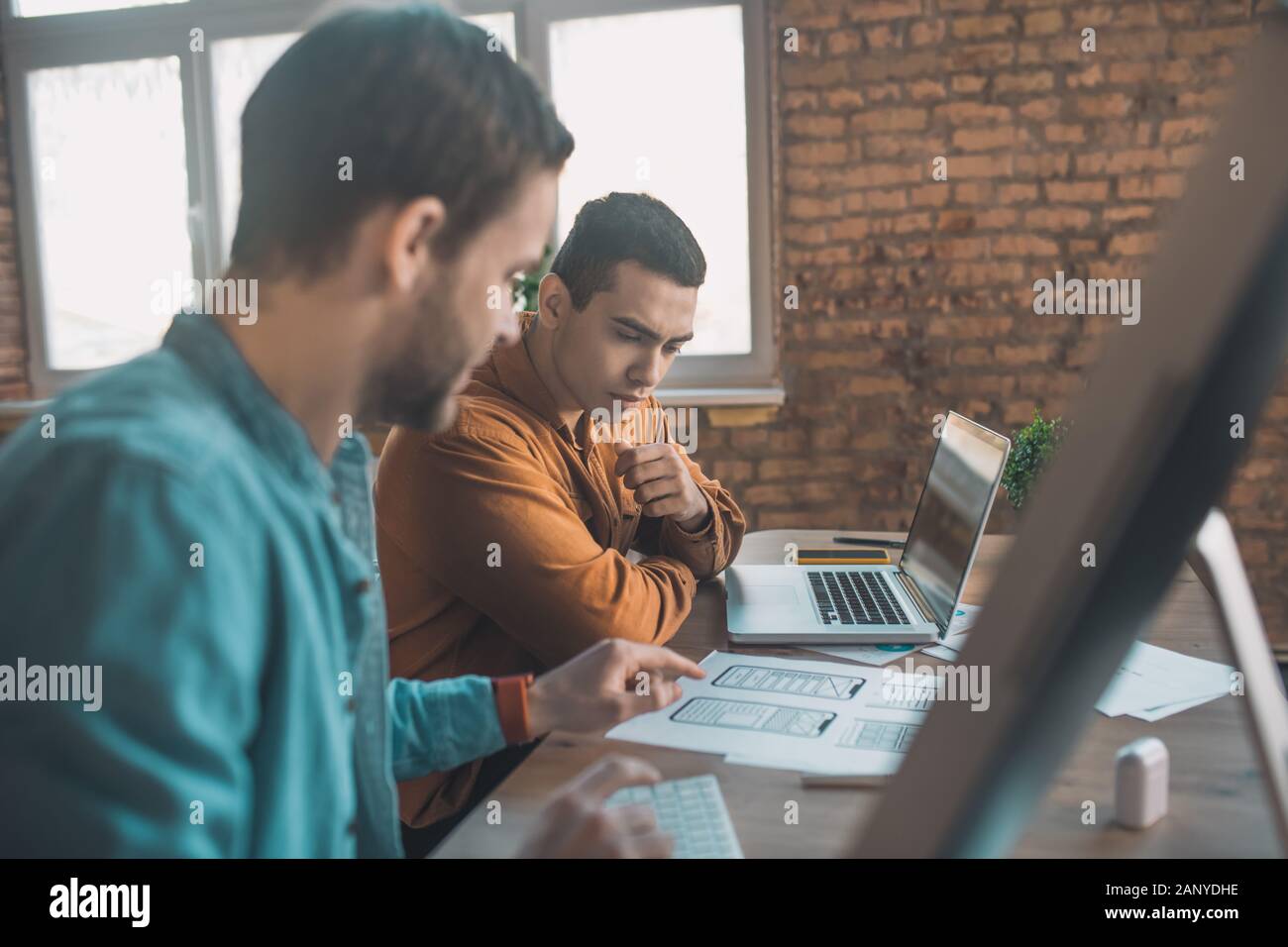 Grave smart giovani uomini a discutere il loro progetto Foto Stock
