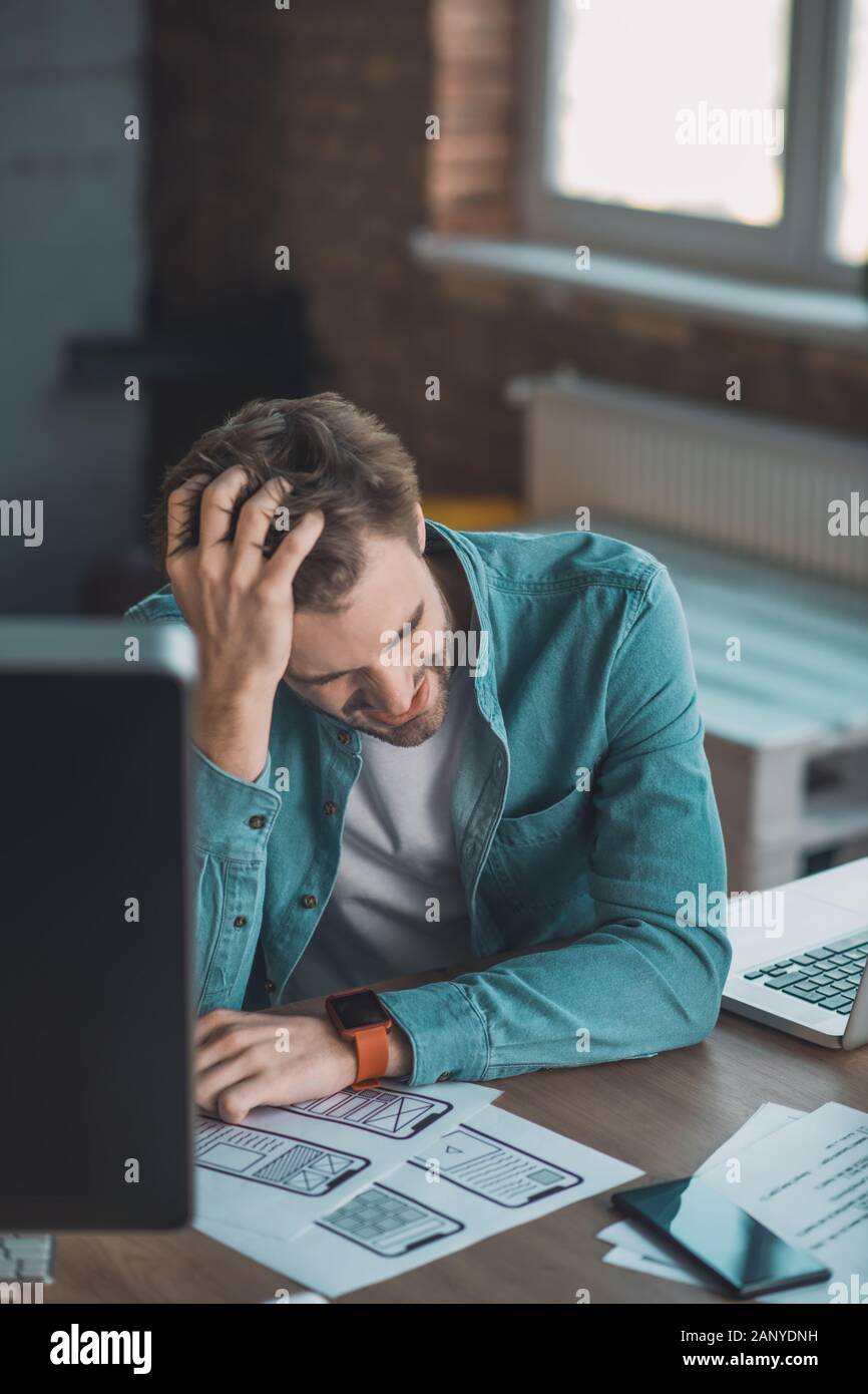 Premuto giovane mettendo la sua mano sulla testa Foto Stock