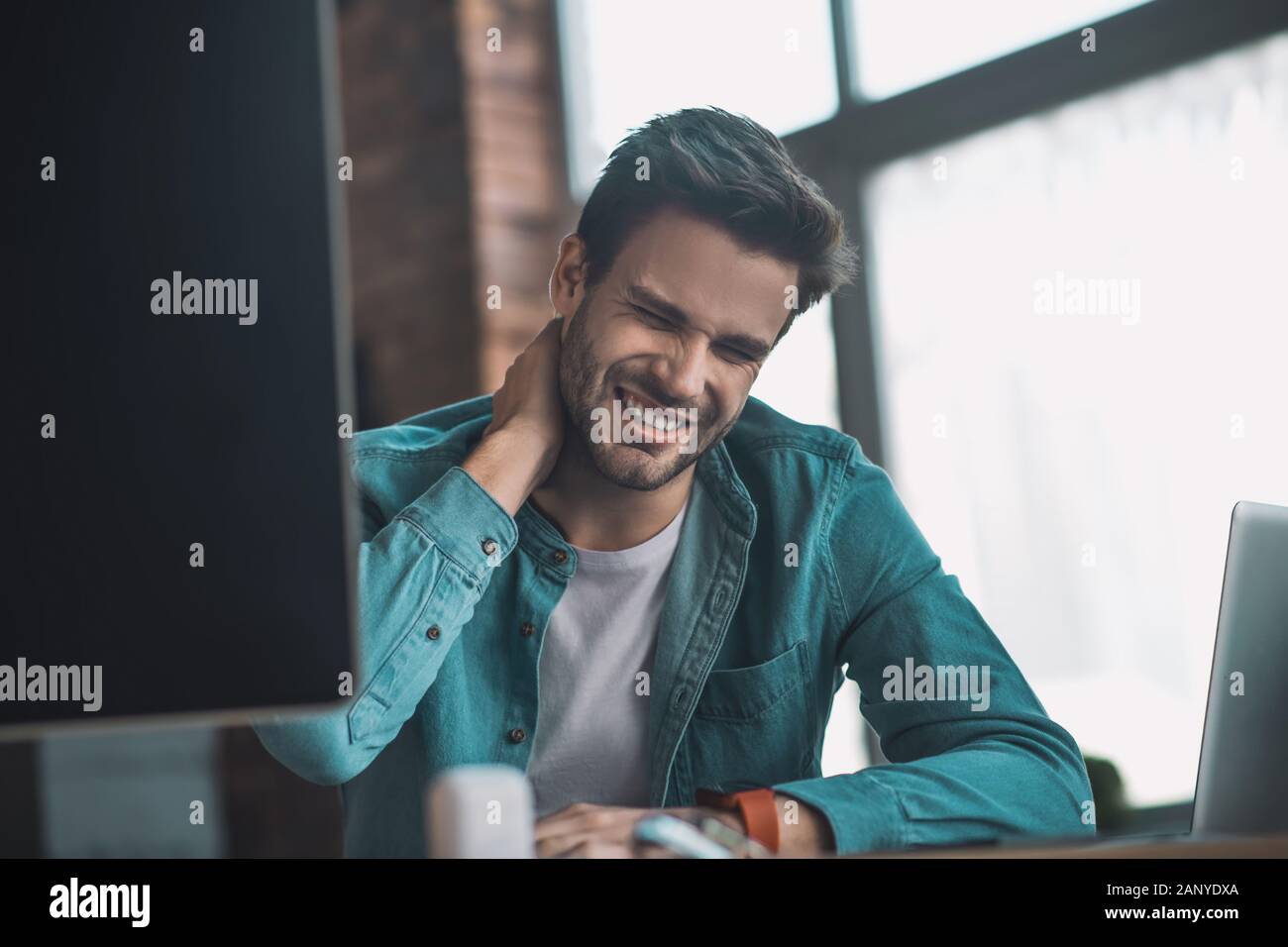 Infelice giovane sentire dolore nel suo collo Foto Stock