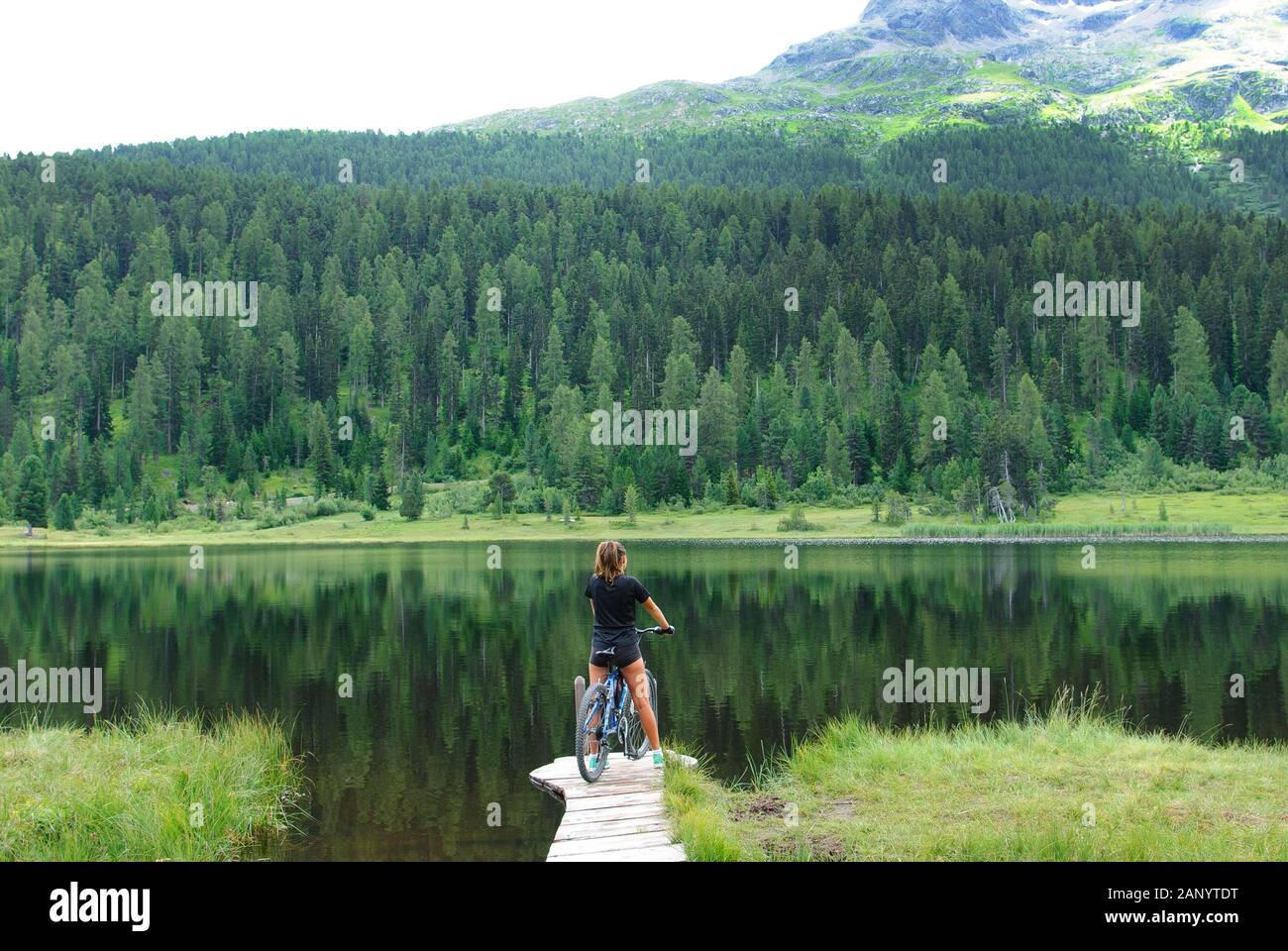 Ragazza giovane con una bicicletta in prossimità di acqua Foto Stock