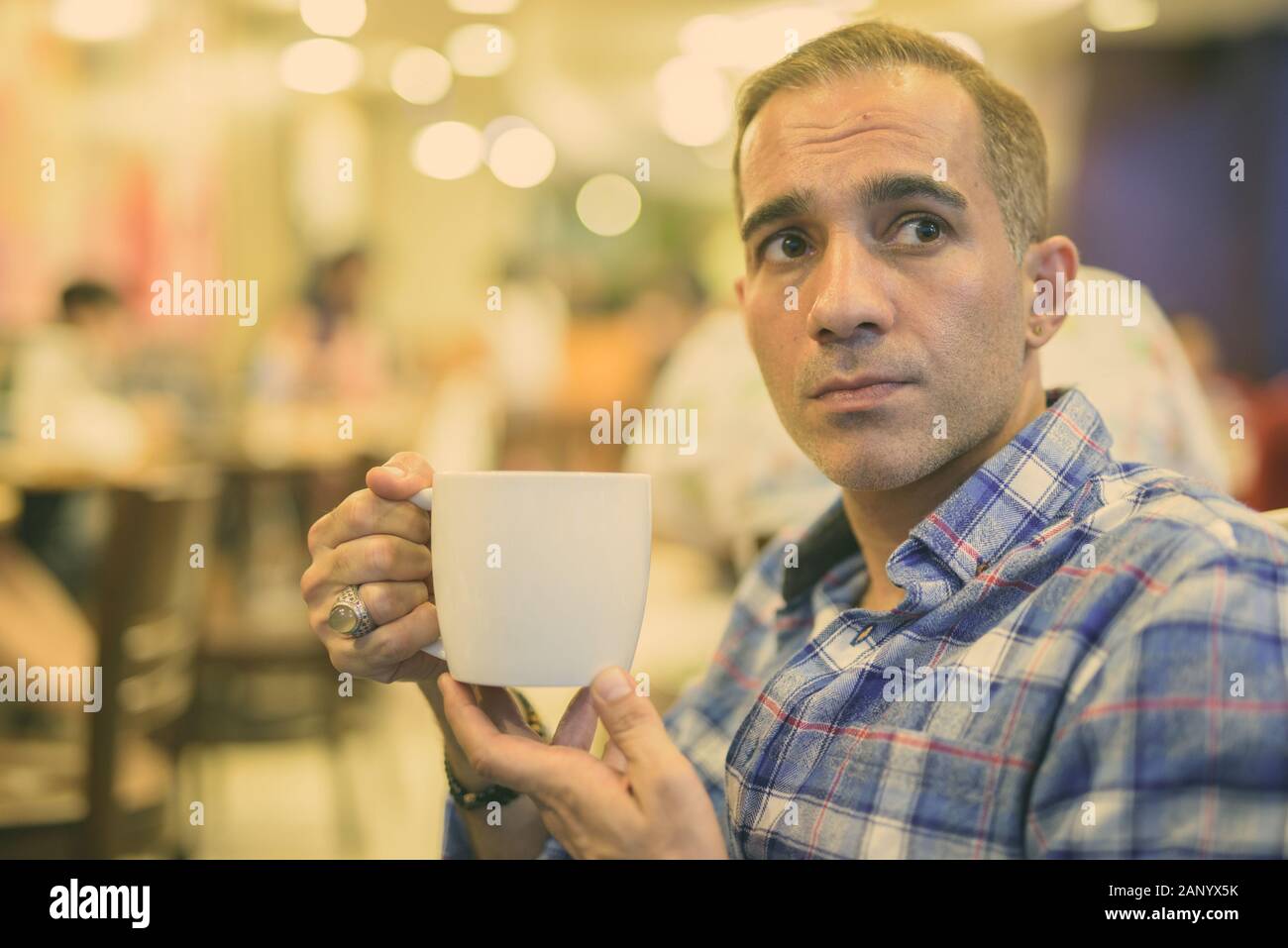 Maturo uomo persiano rilassante all'interno del coffee shop Foto Stock