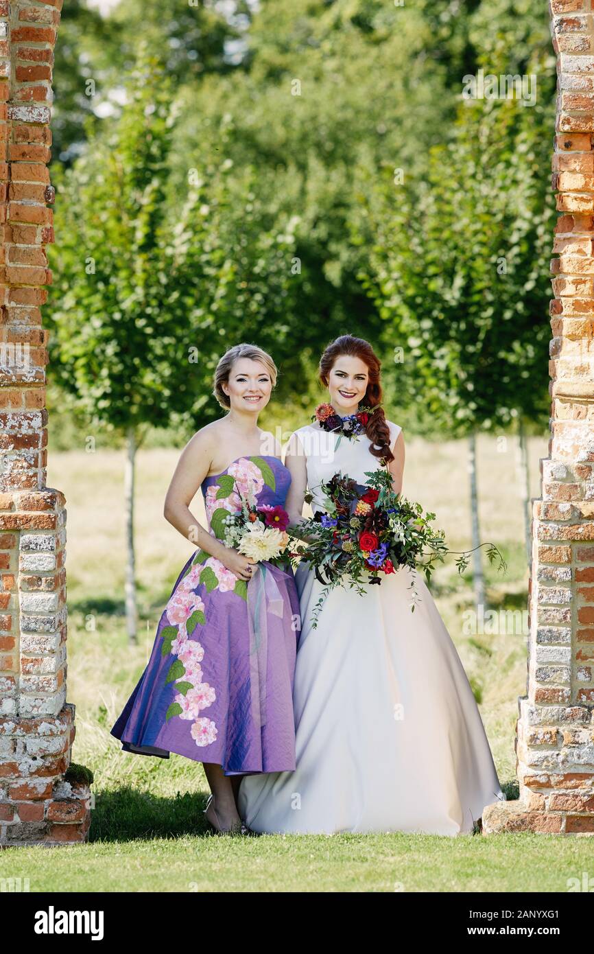 Sposa e sposa in un abito da sposa avorio e abito da sposa viola Foto Stock