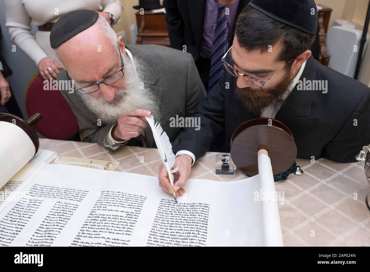 Il completamento della scrittura di una nuova Torah è un processo comune dove congregants, assistito da un graffietto, compilare una lettera. In Bayside, Queens, NYC. Foto Stock
