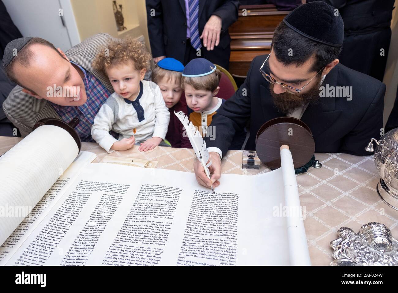 Il completamento della scrittura di una nuova Torah è un processo comune dove congregants, assistito da un graffietto, compilare una lettera. In Bayside, Queens, NYC. Foto Stock